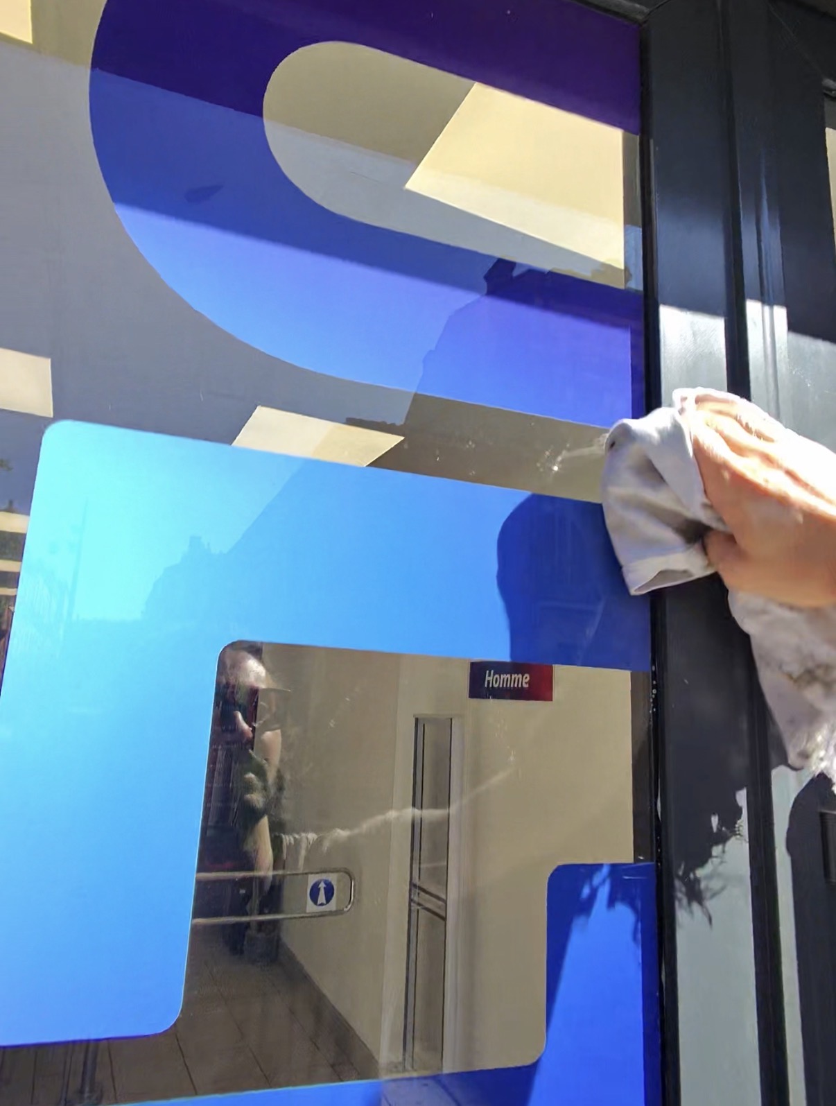 Essuyage des joints et encadrements d'une vitrine au chiffon coton